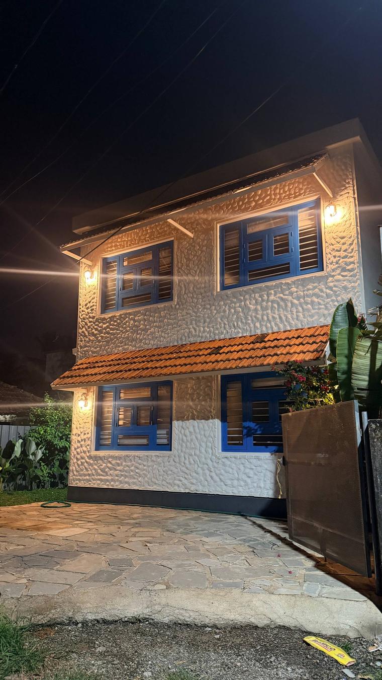 Blue Beach, a textured white building with blue shuttered windows, lit at night